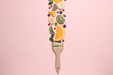 Creative flat lay composition with paint brush, fruits and berries on beige background