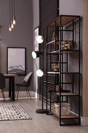 Stylish shelving unit with decor near grey wall indoors. Interior design