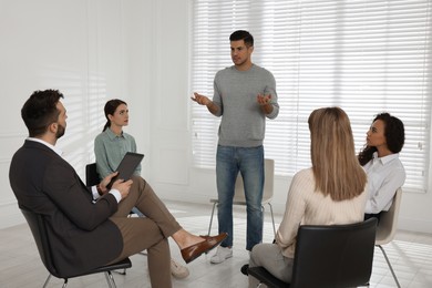 Psychotherapist working with patients at group session indoors