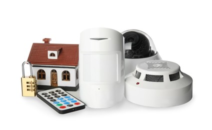 House model, CCTV camera, remote control, lock, smoke and movement detectors on white background. Home security system