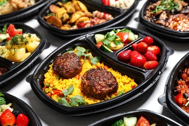 Lunchboxes with different meals on white table. Healthy food delivery