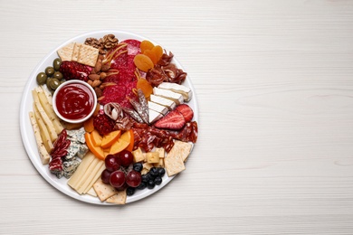 Plate of different appetizers with sauce on white wooden table, top view. Space for text