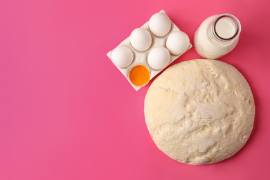 Raw dough and ingredients for pastries on pink background, flat lay. Space for text