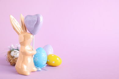 Composition with Easter bunny figure on violet background. Space for text