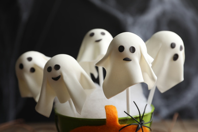 Ghost shaped cake pops on dark background, closeup. Halloween treat
