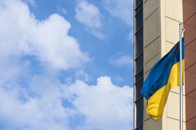 Ukrainian flag and building against cloudy sky