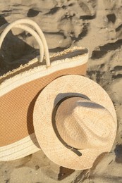 Stylish bag and hat on sand. Beach accessories