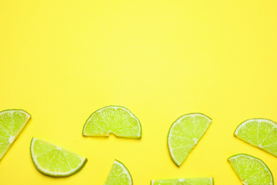 Juicy fresh lime slices on yellow background, flat lay. Space for text