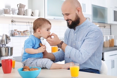 Dad having breakfast with little son in kitchen