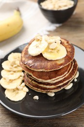 Photo of Plate of banana pancakes on wooden table, closeup