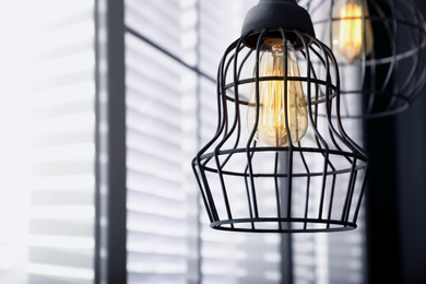 Image of Stylish metallic pendant lamp with Edison light bulb indoors