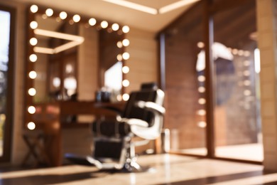 Photo of Blurred view of stylish barbershop interior with hairdresser workplace