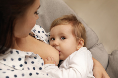Woman breastfeeding her little baby at home, closeup