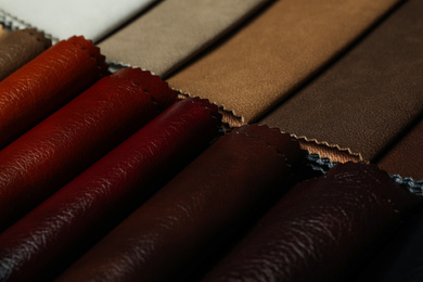 Different leather samples as background, closeup view
