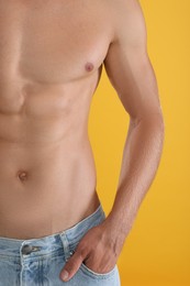 Shirtless man with slim body on yellow background, closeup