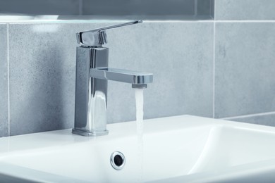 Stream of water flowing from tap in bathroom