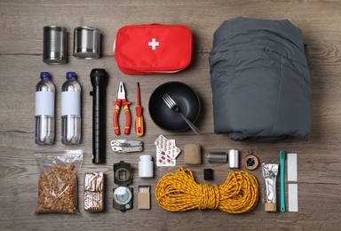 Disaster supply kit for earthquake on wooden table, flat lay