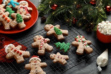 Making homemade Christmas cookies. Gingerbread people and festive decor on black table