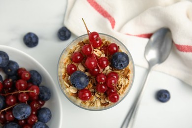 Delicious yogurt parfait with fresh berries on white table, flat lay