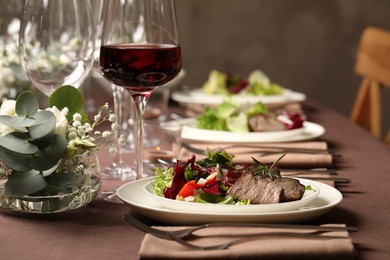 Delicious grilled meat with vegetables and wine served on table in restaurant