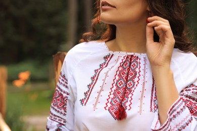 Woman in beautiful embroidered shirt outdoors, closeup. Ukrainian national clothes