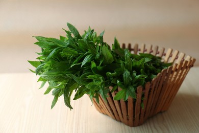 Beautiful green mint in basket on white wooden table