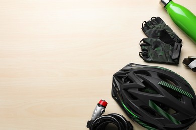 Flat lay composition with different cycling accessories on wooden background, space for text