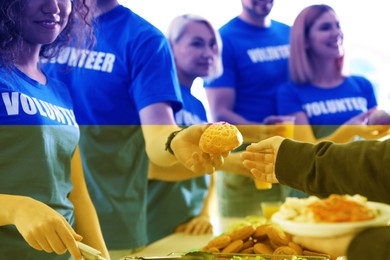 Double exposure of volunteers serving food to refugees and Ukrainian flag, closeup. Help during war