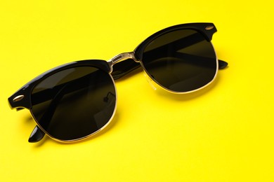 New stylish elegant sunglasses on yellow background
