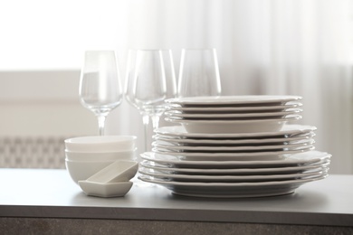 Set of clean dishware and wineglasses on table indoors