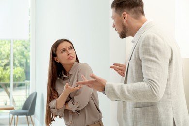 Photo of Man screaming at woman in office. Toxic work environment