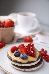 Photo of Crunchy rice cakes with peanut butter and sweet berries on plate