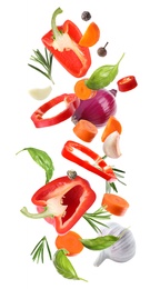 Set of different fresh vegetables and spices falling on white background