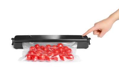 Woman using button on sealer for vacuum packing with plastic bag of cherry tomatoes on white background, closeup