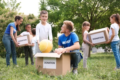Volunteers and kids with donation boxes in park