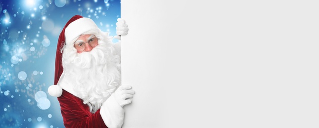 Image of Santa Claus with blank banner on blurred blue background. Space for design