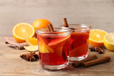 Aromatic punch drink and ingredients on wooden table