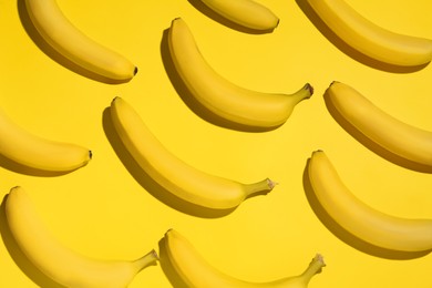 Ripe sweet bananas on yellow background, flat lay