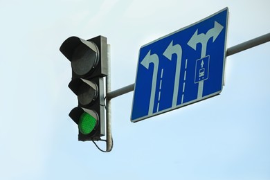 Traffic light against blue sky in city