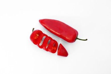 Photo of Whole and cut red hot chili peppers on white background, flat lay