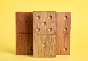 Wooden domino tiles with pips on yellow background