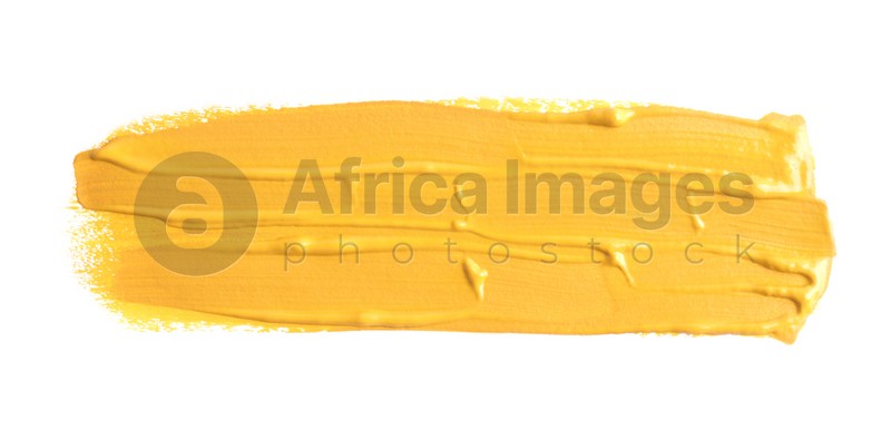 Photo of Yellow paint stroke drawn with brush on white background, top view