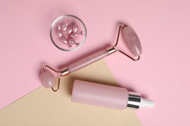 Face roller and skin care products on color background, flat lay