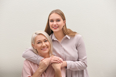 Mother and her adult daughter on white background