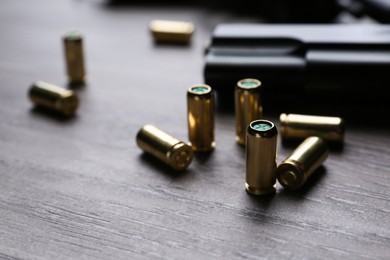 Pistol bullets on wooden table, closeup. Professional gun