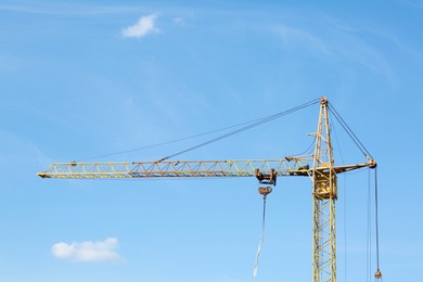 Modern tower crane against blue sky. Construction site