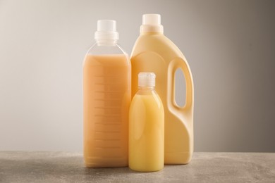 Different bottles with detergents on grey table