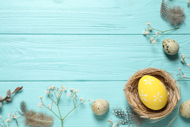 Flat lay composition with Easter eggs on light blue wooden background. Space for text