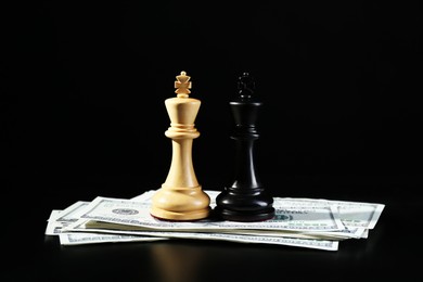 Money, white and black kings against dark background. Business competition concept