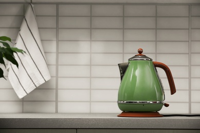 Modern electric kettle on grey kitchen counter. Space for text